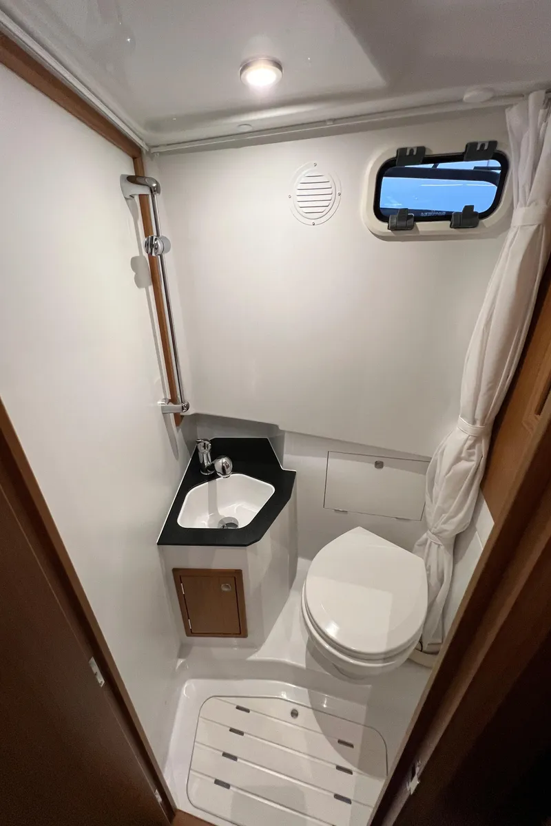 Slide: The Image of 2025 Sargo All Season boat bathroom with compact design, featuring a toilet, sink, and shower. - 13