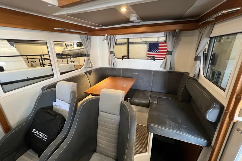 Slide: The Image of Interior of 2025 Sargo All Season boat with seating, table, and American flag. - 17