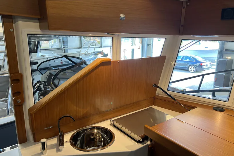 Slide: The Image of Interior of 2025 Sargo All Season boat with wooden cabinetry and compact kitchen area. - 8