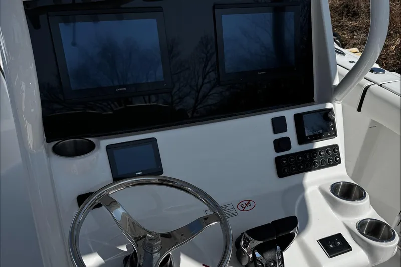 Slide: The Image of 2025 Tidewater 282 CC Adventure boat dashboard with dual screens and steering wheel. - 17