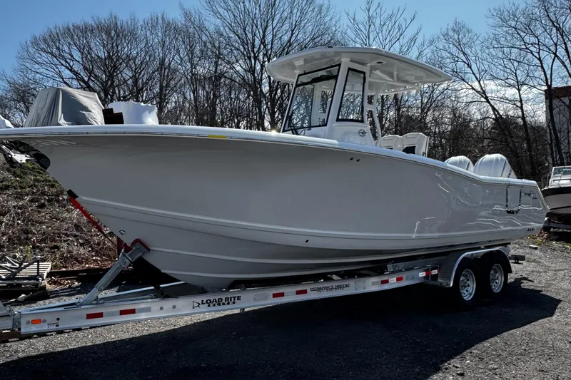 Slide: The Image of 2025 Tidewater 282 CC Adventure boat on trailer, parked outdoors. - 3