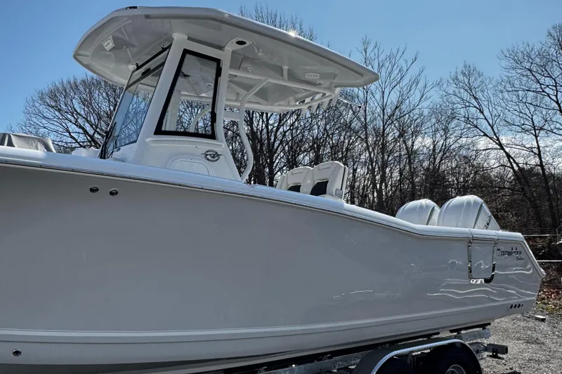 Slide: The Image of 2025 Tidewater 282 CC Adventure boat, sleek design, parked outdoors, clear sky background. - 5