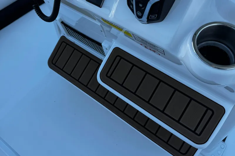 Slide: The Image of 2025 Tidewater 232 LXF boat console with footrests and cup holder. - 13