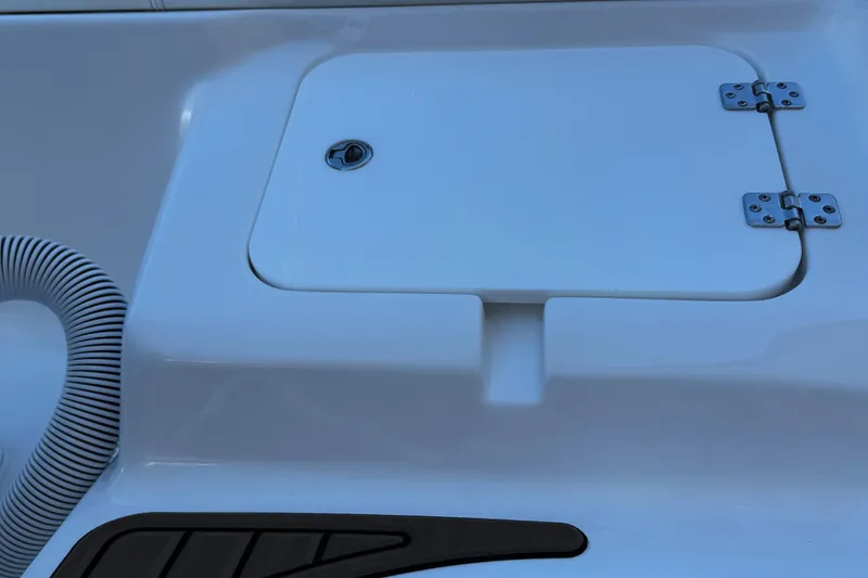 Slide: The Image of 2025 Tidewater 232 LXF boat deck with storage compartment and hose. - 19