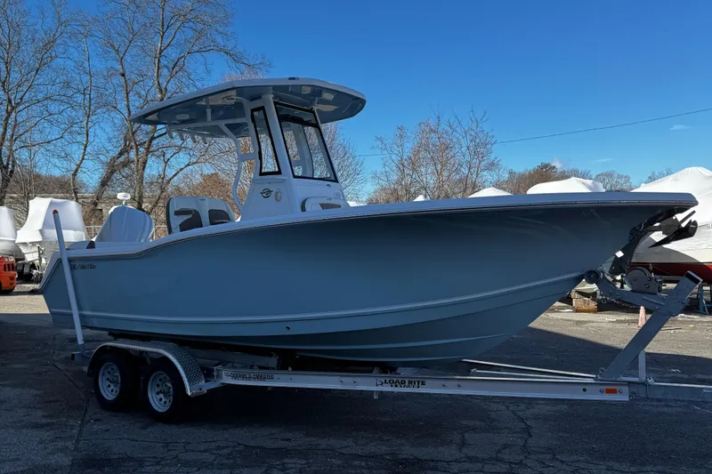 Slide: The Image of 2025 Tidewater 232 LXF boat on trailer, parked outdoors under clear blue sky. - 3