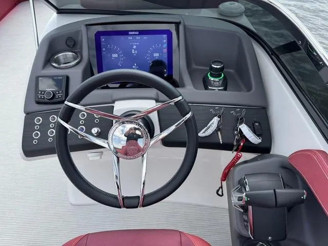 Slide: The Image of Interior of 2025 Bennington QX Swingback 30, featuring red seating and control panel. - 13