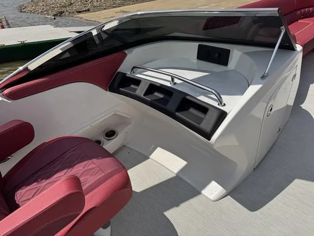 Slide: The Image of 2025 Bennington QX Swingback 30 QXSBWAX2 boat interior with red seating and open storage hatch. - 14