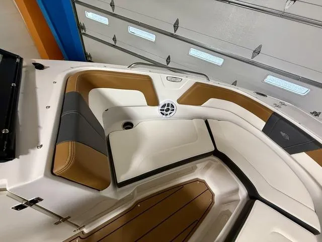 Slide: The Image of 2025 Chaparral 23 SSi boat interior with tan and gray seating in a garage. - 14