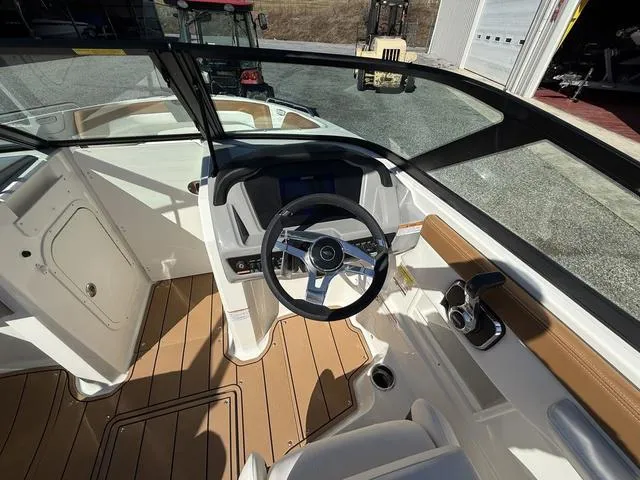 Slide: The Image of 2025 Chaparral 23 SSi boat cockpit with modern steering and wood accents. - 13