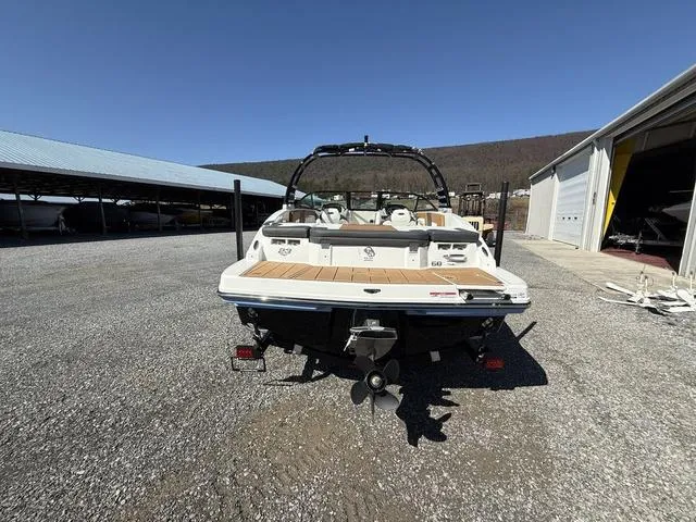 Slide: The Image of 2025 Chaparral 23 SSi boat, rear view, parked outdoors on gravel near storage buildings. - 4