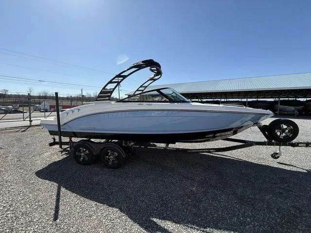 Slide: The Image of 2025 Chaparral 23 SSi boat on trailer, parked outdoors under clear blue sky. - 5