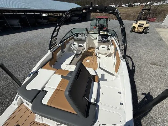 Slide: The Image of 2025 Chaparral 23 SSi boat with sleek interior and modern design, parked outdoors. - 8