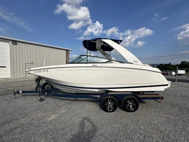 Slide: The Image of 2022 Regal 22 FasDeck boat on trailer, parked outdoors under a blue sky. - 3