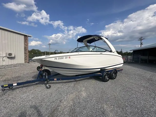 Slide: The Image of 2022 Regal 22 FasDeck boat on trailer, parked outdoors under a blue sky. - 4