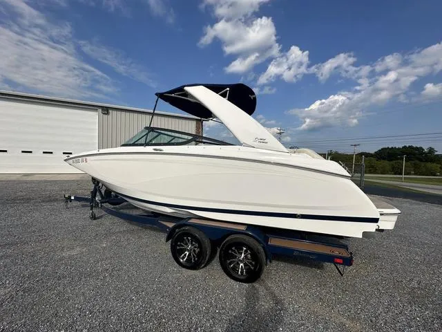 Slide: The Image of 2022 Regal 22 FasDeck boat on trailer, parked outdoors under a partly cloudy sky. - 5