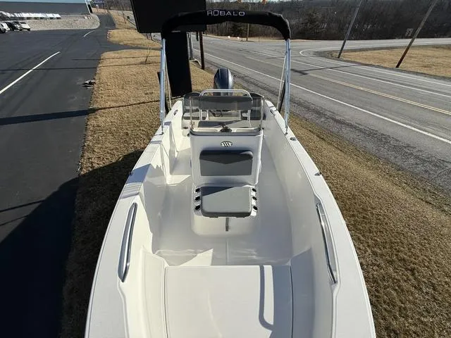 Slide: The Image of 2025 Robalo R160 boat, sleek design, parked on grass near a road. - 10
