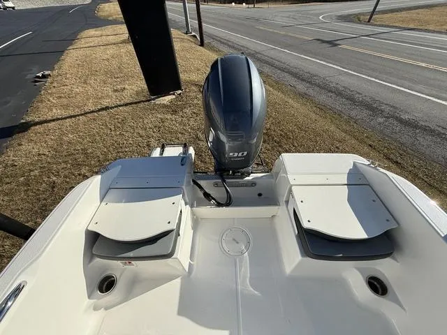 Slide: The Image of 2025 Robalo R160 boat with outboard motor, parked on grass near a road. - 11