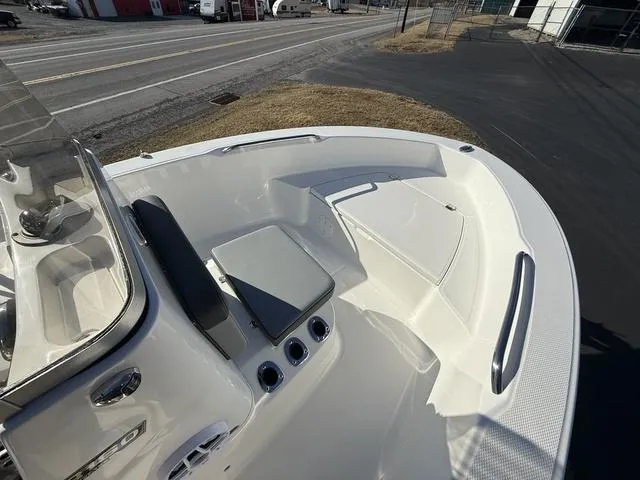 Slide: The Image of 2025 Robalo R160 boat interior with seating and storage, parked on asphalt near a road. - 13