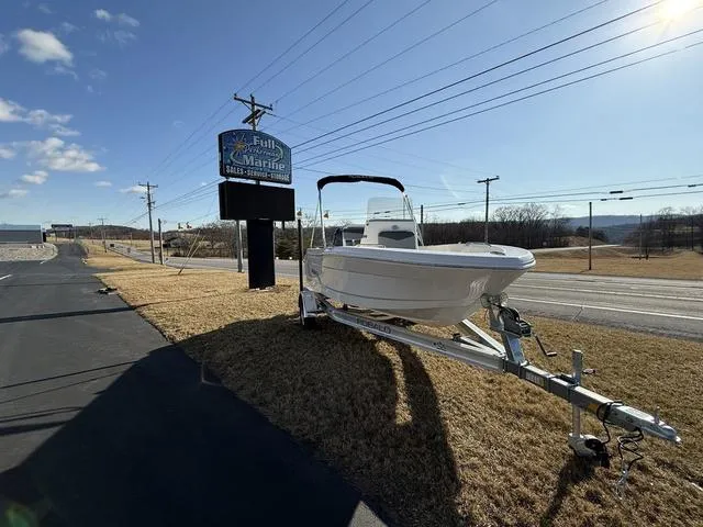 Slide: The Image of 2025 Robalo R160 boat on trailer near a marine store sign. - 3