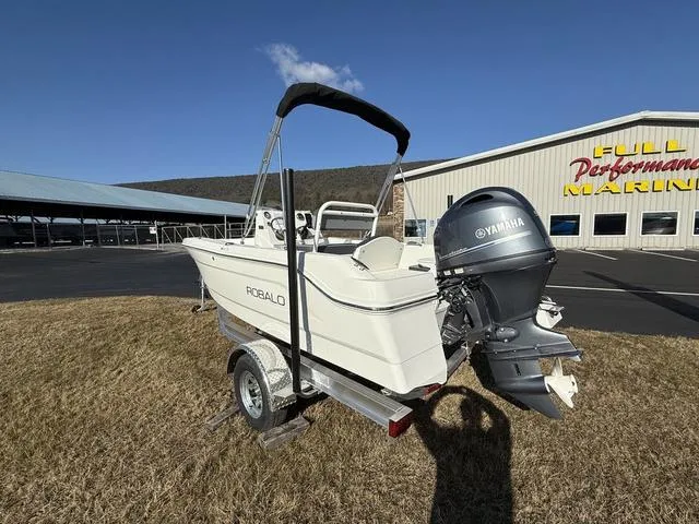 Slide: The Image of 2025 Robalo R160 boat with Yamaha engine on trailer, parked near Full Performance Marine. - 4