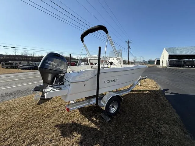 Slide: The Image of 2025 Robalo R160 boat on trailer with Yamaha outboard motor, parked on grass. - 5