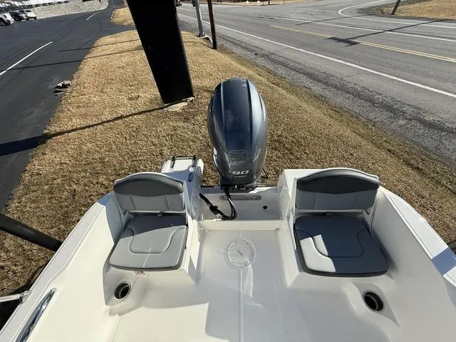 Slide: The Image of 2025 Robalo R160 boat with dual seating and outboard motor, parked on roadside. - 7