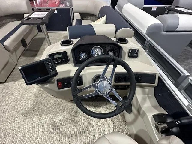 Slide: The Image of 2024 Bennington 22' SSB boat dashboard with steering wheel and navigation controls. - 14