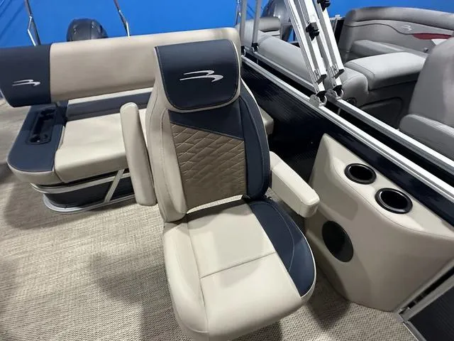 Slide: The Image of 2024 Bennington 22' SSB boat interior with beige and navy seating, cup holders, and modern design. - 8