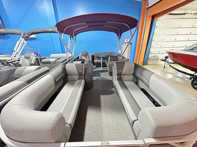 Slide: The Image of 2024 Bennington 188 SVL pontoon boat with spacious seating and canopy in showroom. - 3