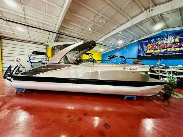 Slide: The Image of 2023 Bennington 25 RXSBA pontoon boat displayed indoors on red flooring. - 1