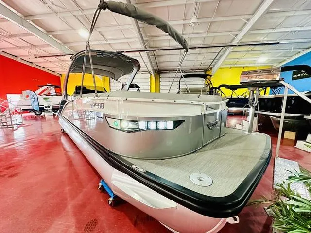 Slide: The Image of 2023 Bennington 25 RXSBA pontoon boat in showroom with vibrant red and yellow walls. - 10
