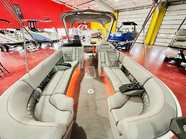 Slide: The Image of 2023 Bennington 25 RXSBA pontoon boat interior with luxurious seating in a showroom. - 11