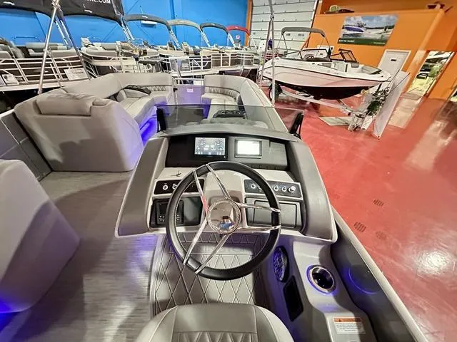 Slide: The Image of 2023 Bennington 25 RXSBA boat interior with modern dashboard and seating in showroom. - 16