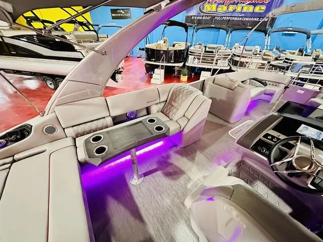 Slide: The Image of 2023 Bennington 25 RXSBA pontoon boat interior with purple LED lighting and luxurious seating. - 17