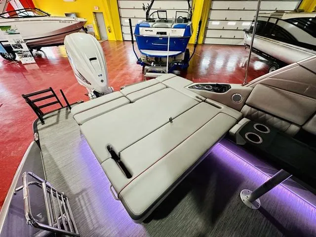 Slide: The Image of 2023 Bennington 25 RXSBA boat interior with seating and motor in showroom. - 18