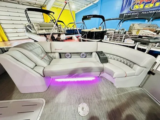 Slide: The Image of 2023 Bennington 25 RXSBA boat interior with plush seating and ambient lighting. - 23