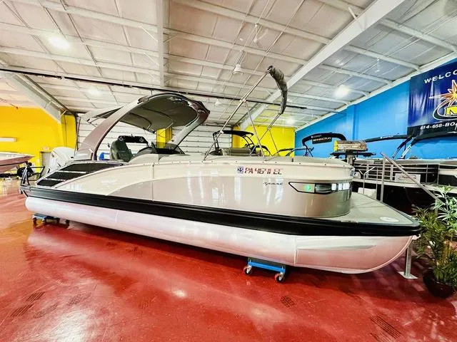 Slide: The Image of 2023 Bennington 25 RXSBA pontoon boat displayed indoors on red flooring. - 4