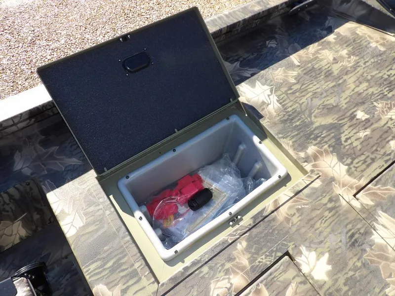 Slide: The Image of 2025 Crestliner XFC 189 boat storage compartment with open lid, revealing interior contents. - 12