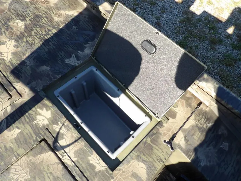 Slide: The Image of Open storage compartment on 2025 Crestliner XFC 189 boat with camouflage design. - 14