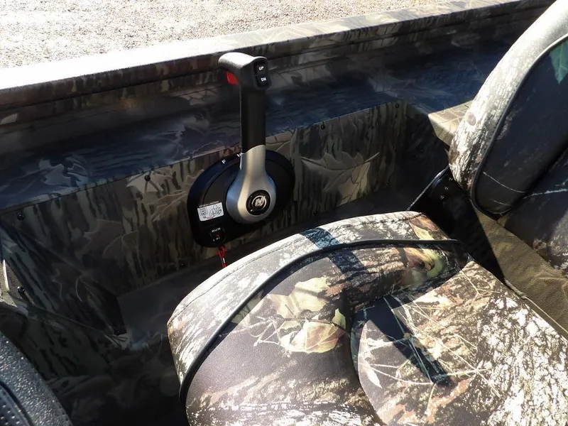 Slide: The Image of 2025 Crestliner XFC 189 boat interior with camouflage seats and control lever. - 19