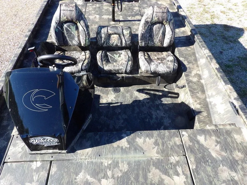 Slide: The Image of 2025 Crestliner XFC 189 boat interior with camouflage seating and steering console. - 21