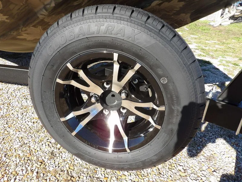 Slide: The Image of 2025 Crestliner XFC 189 wheel with Globaltrax tire on gravel surface. - 32
