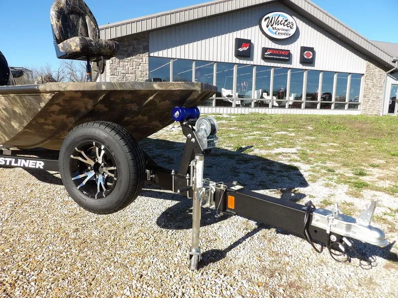 Slide: The Image of 2025 Crestliner XFC 189 boat on trailer outside dealership, showcasing camo design and modern features. - 33