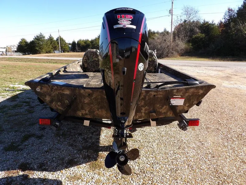 Slide: The Image of 2025 Crestliner XFC 189 boat with powerful outboard motor, parked on gravel. - 6