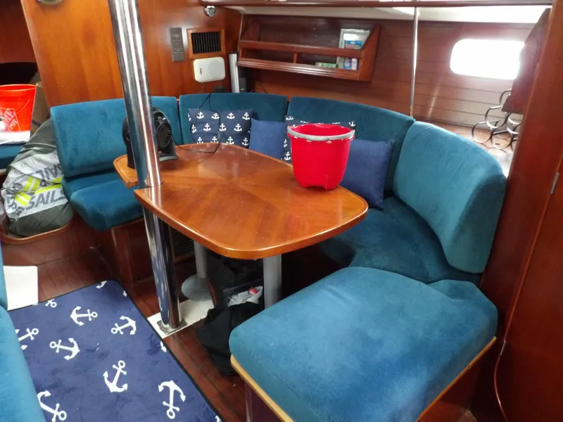 Slide: The Image of Interior of 1994 Beneteau Oceanis 351 sailboat with blue seating and wooden table. - 23