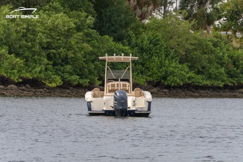 Slide: The Image of 2023 Scout 215 XSF boat on water, surrounded by lush greenery. - 2