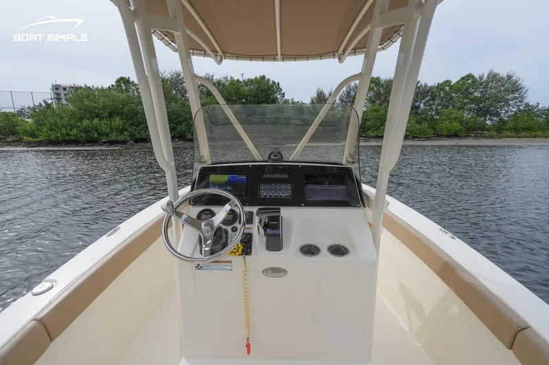 Slide: The Image of 2023 Scout 215 XSF boat console with steering wheel on calm water. - 4