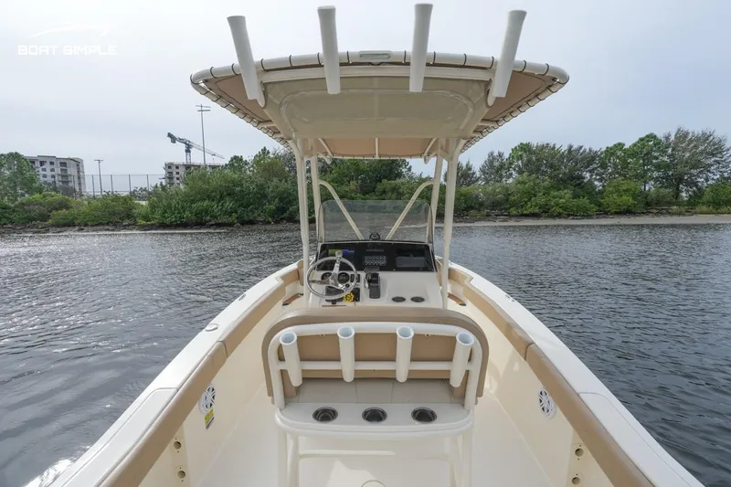 Slide: The Image of 2023 Scout 215 XSF boat on water, featuring a center console and T-top canopy. - 5