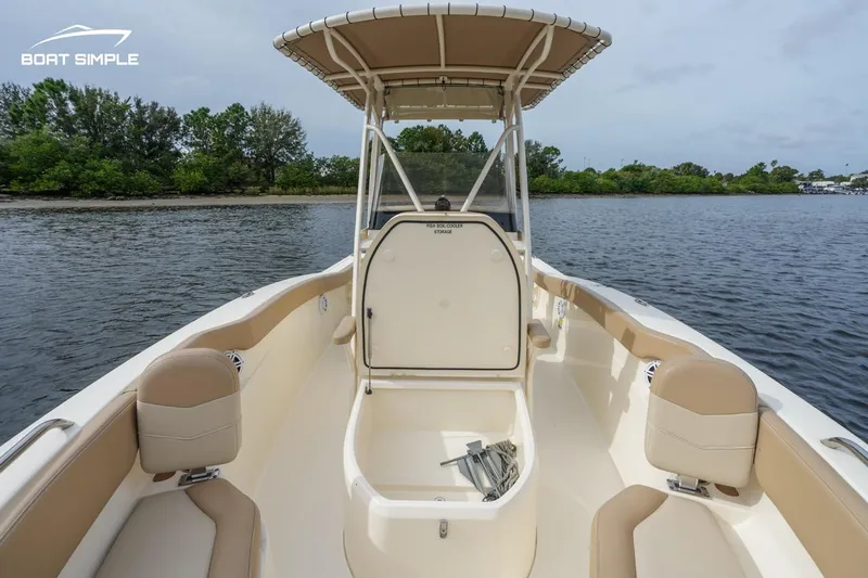 Slide: The Image of 2023 Scout 215 XSF boat interior with seating and storage, on calm water. - 8