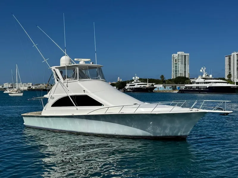 Slide: The Image of Ocean Yachts 48 Convertible 2000 model, cruising in a marina with city skyline backdrop. - 11